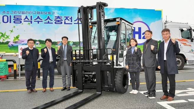 수소모빌리티 실증사업 킥오프 행사에 참석한 관계자들이 수소지게차 옆에서 기념촬영을 하고 있다. 사진 왼쪽부터 김기철 현대글로비스 상무, 금영범 현대모비스 상무, 우항수 울산테크노파크 단장, 김미금 중소벤처기업부 사무관, 인정석 울산광역시 사무관, 이재훈 현대제뉴인 상무＜사진제공:현대모비스＞