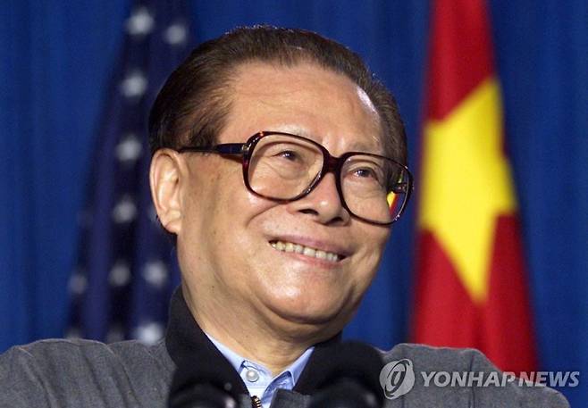 FILE PHOTO: China's President Jiang Zemin smiles as he listens to the translation during a joint press conference with United States President George W. Bush after the two met privately at Bush's Crawford, Texas ranch, U.S. October 25, 2002. REUTERS/Jeff Mitchell/File Photo