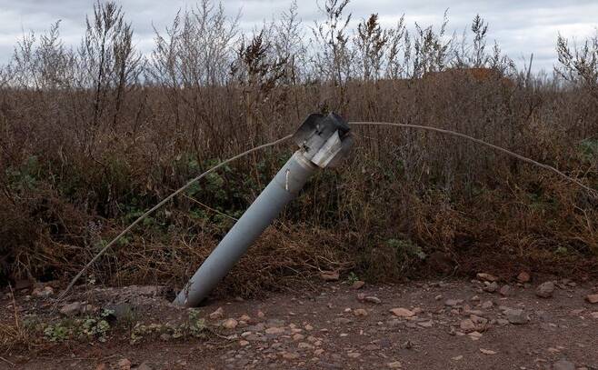 지난 10월 우크라이나 하르키우 지역에 떨어진 러시아의 미사일이 전선에 걸린 후 땅에 박혔다. 사진 로이터 연합뉴스