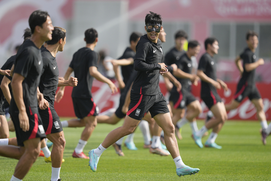 Son Heung-min, center, and other members of Team Korea warm up during an official training session on the eve of the group H World Cup football match between South Korea and Portugal, at the Al Egla Training Site 5 in Doha, Qatar, Thursday. [AP/YONHAP]