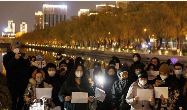 지난달 27일 중국 베이징에서 열린 우루무치 화재 참사 추도식 도중 시민들이 코로나19 봉쇄 조치에 반대하며 시위를 하고 있다. ⓒ 로이터/연합뉴스