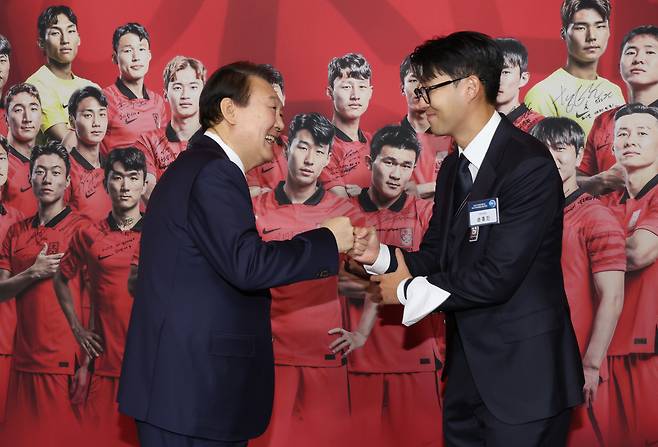 8일 청와대 영빈관에서 열린 축구 국가대표팀 환영 만찬에서 윤석열 대통령이 주장 손흥민 선수로부터 2022 카타르 월드컵 기간 착용했던 주장 완장을 선물받은 뒤 주먹을 맞대고 있다. [연합]