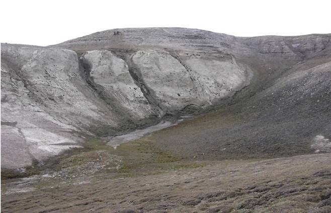옛 환경 디엔에이를 추출한 그린란드 북부 해안의 카프 쾨벤하운 층 모습. 위에 2명의 연구자가 시료를 채취하는 모습이 보인다. 스벤트 푼더 제공.