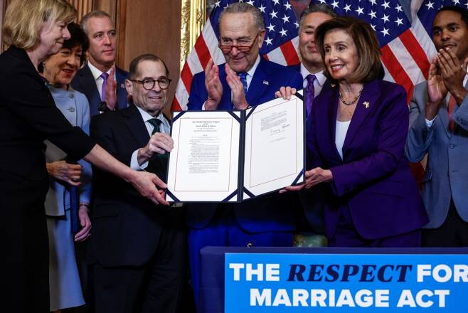 U.S. House Speaker Nancy Pelosi (D-CA) and fellow members of Congress hold "The Respect for Marriage Act" during a bill enrolment ceremony on Capitol Hill, in Washington, U.S., December 8, 2022. REUTERS/Evelyn Hockstein /사진=로이터=뉴스1