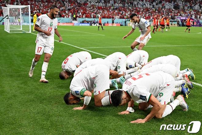 (도하 AFP=뉴스1) 정윤미 기자 = 27일(현지시간) 카타르 수도 도하 알 투마마 스타디움에서 열린 조별리그 F조 2차전에서 피파랭킹(지난달 기준) 22위 모로코가 2위 벨기에를 2대 0으로 물리치고 1승 1무로 승점 4점을 획득했다. 사진은 압델하미드 사비리 모로코 선수가 이번 월드컵 모로코에 첫 골을 안겨주어 동료 선수들이 다함께 기뻐하고 있다. 2022.11.27 ⓒ AFP=뉴스1 Copyright (C) 뉴스1. All rights reserved. 무단 전재 및 재배포 금지.