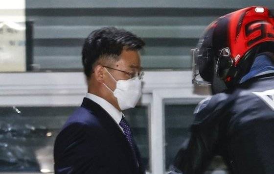 대장동 개발 로비ㆍ특혜 의혹의 핵심 인물인 화천대유자산관리(화천대유) 대주주 김만배 씨가 구속영장이 기각되자 15일 경기도 의왕 서울구치소를 나서며 헬멧 쓴 남성(최우향)의 도움을 받고 있다. 연합뉴스