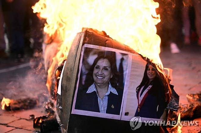 대통령 사진 불태우는 페루 시위대 (쿠스코 AFP=연합뉴스) 20일(현지시간) 페루 쿠스코에서 페드로 카스티요 전 대통령 탄핵과 구금에 항의하는 시위대가 디나 볼루아르테 대통령 사진을 불태우고 있다. 2022.12.21