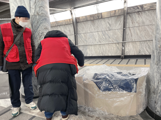 브릿지센터 상담원들이 8일 오후 9시쯤 서울 광화문역 안을 돌며 거리상담을 진행하고 있다. 한 노숙인이 추워진 날씨를 견디기 위해 상자와 비닐로 바람막이를 만들어 쉬고 있다. 최은서 기자