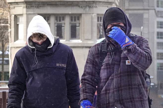 23일 미국 시카고의 한 거리에서 모자와 마스크를 쓰고 중무장한 남성 2명이 걸어가고 있다./AFPBBNews=뉴스1