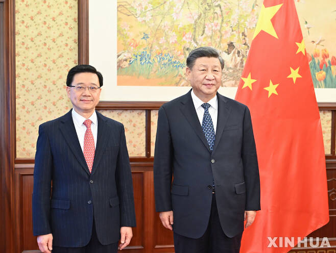[베이징=신화/뉴시스] 23일 중국 베이징 중난하이에서 시진핑 중국 국가주석(오른쪽)이 존 리 홍콩 행정장관으로부터 업무보고를 받기 이전 기념 촬영을 하고 있다. 2022.12.24