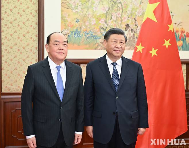 [베이징=신화/뉴시스] 23일 중국 베이징 중난하이에서 시진핑 중국 국가주석(오른쪽)이 호얏셍(賀一誠) 마카오 행정장관으로부터 업무보고를 받기 이전 기념 촬영을 하고 있다. 2022.12.24