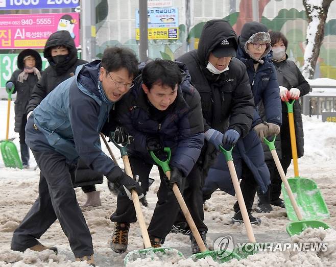 눈 치우는 강기정 광주시장 (광주=연합뉴스) 강기정(맨 왼쪽) 광주시장이 24일 오전 광주 북구 문흥동 일원에서 자원봉사자, 직원들과 함께 내 집 앞 눈 치우기에 참여해 인도, 차도에 쌓인 눈을 치우고 있다. 2022.12.24 [광주시 제공. 재판매 및 DB 금지] sangwon700@yna.co.kr