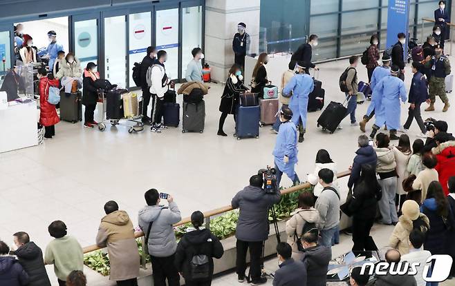 (인천공항=뉴스1) 민경석 기자 = 2일 오전 인천국제공항 제1여객터미널 입국장에서 중국에서 입국한 해외여행객들이 공항 의료진 및 군 관계자들의 안내를 받아 집결하고 있다. 방역당국은 이날부터 중국발 국내·외국인 입국자에 대한 방역을 강화했다. 중국발 입국자는 모두 유전자증폭(PCR) 검사를 받아야 한다. 2023.1.2/뉴스1 Copyright (C) 뉴스1. All rights reserved. 무단 전재 및 재배포 금지.