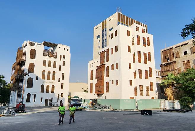 어느정도 보존·정비 작업이 마무리된 건축물과 작업중인 인부들.