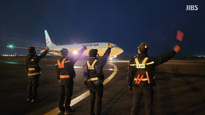 오늘(6일) 새벽 한국공항 소속 지상조업원들이 제주국제공항에서 이륙하는 항공편에 손을 흔드는 모습.