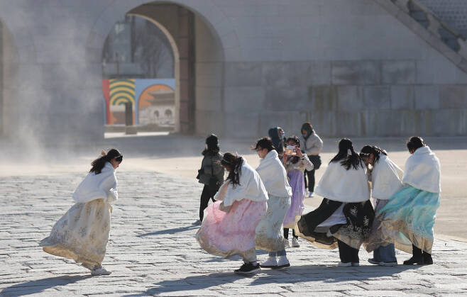 설 연휴 마지막날인 24일 서울 종로구 경복궁을 찾은 관람객들이 한파에 몸을 웅크린 채로 걷고 있다. 연합뉴스