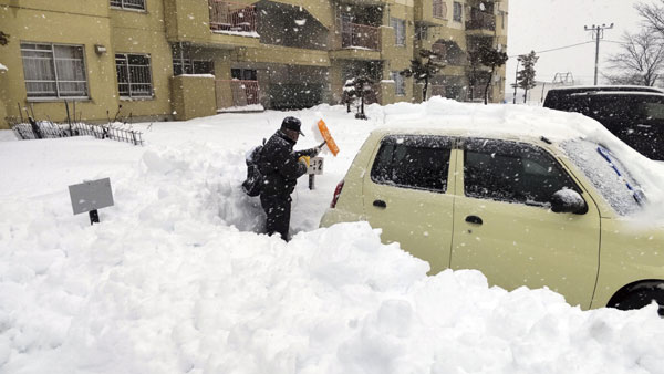 지난해 12월 24일 일본 홋카이도에서 시민이 쌓인 눈을 치우고 있다.