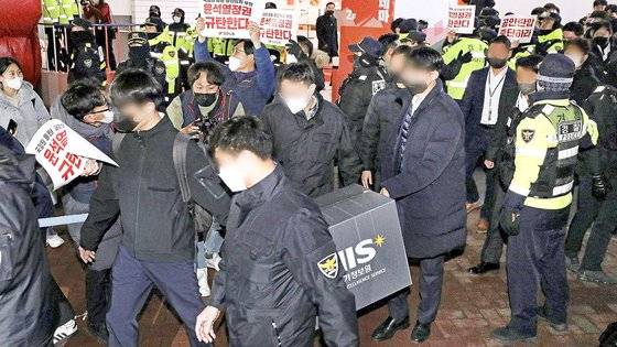 국가정보원 관계자들이 지난 18일 오후 서울 중구 전국민주노동조합총연맹 서울 사무실에서 국가보안법 위반 혐의로 압수수색을 마친 후 압수품 상자를 들고 나가고 있다.뉴스1