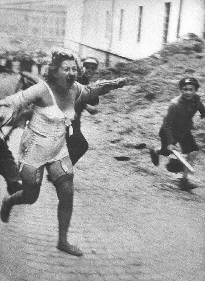 1941년 7월 독일이 점령한 폴란드 동부에서 유대인 여성이 청년과 소년들에게 괴롭힘을 당하며 쫓기고 있다. 나치 점령지에서 유대인들이 얼마나 괴롭힘을 당했는지 증명하는 사진이다.