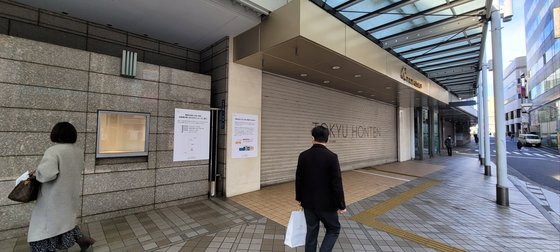 지난달 31일 폐업한 일본 시부야에 있는 도큐백화점 본점 앞. 폐업을 알리는 안내문을 행인들이 바라보고 있다. 도쿄=김현예 특파원