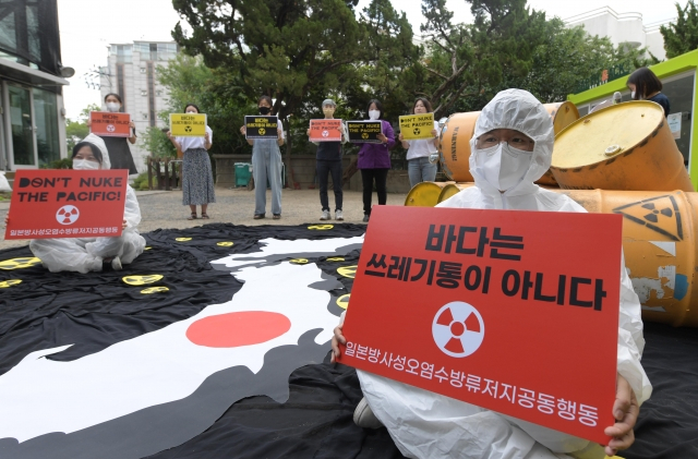 시민들이 지난해 6월 서울 종로구 환경운동연합 마당에서 열린 일본 후쿠시마 방사성 오염수 방류 계획 철회 촉구 기자회견에서 손 피켓을 들고 있다. 이한형 기자