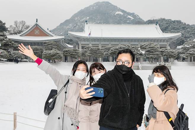 서울을 비롯한 수도권과 중부 지방에 많은 눈이 내린 2022년 12월 21일 서울 종로구 청와대를 찾은 관람객들이 눈 쌓인 청와대 본관을 배경으로 사진을 찍고 있다. /뉴스1