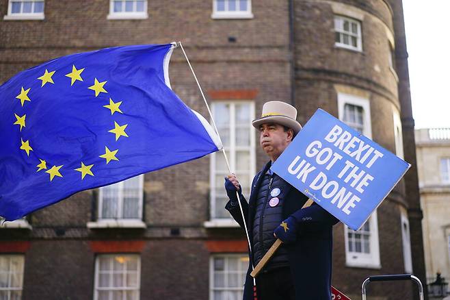 2023년 1월 9일 영국 런던 도심에서 한 시민이 “브렉시트가 영국을 끝장냈다”고 쓴 손팻말과 유럽연합(EU) 국기를 들고 브렉시트에 반대하는 시위를 하고 있다. 런던/AP 연합뉴스