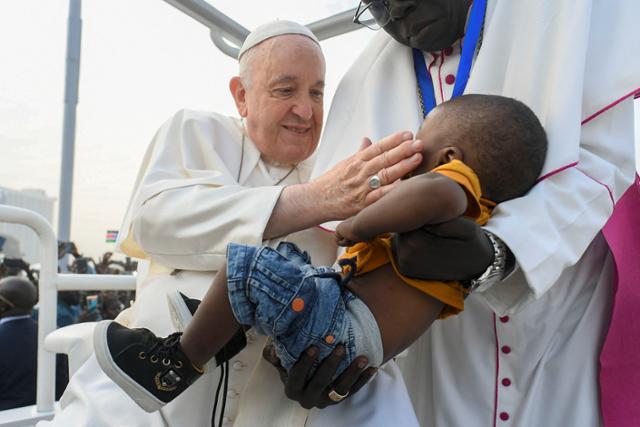 프란치스코 교황이 5일 남수단 주바의 존 가랑 광장으로 미사를 위해 들어서며 한 어린이를 어루만지고 있다. 주바=로이터 연합뉴스