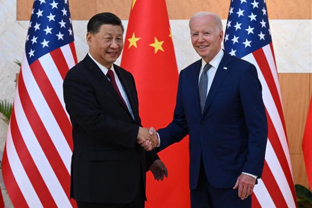 조 바이든(오른쪽) 미국 대통령과 시진핑 중국 국가주석이 지난해 11월 14일 주요 20개국(G20) 정상회의가 열린 인도네시아 발리에서 미중 정상회담을 갖기에 앞서 웃으며 악수하고 있다. 발리=AFP 연합뉴스