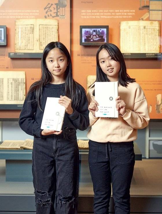 김윤슬(왼쪽)·나예현 학생기자가 자신이 아끼는 책을 보관할 책 보관상자를 만들고, 책 제목·소장자·보관상자 제작일 등 관련 정보를 기재한 이름표를 붙였다.