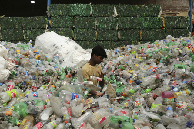 인도 잠무 외곽의 한 공업지역에서 노동자가 재활용할 플라스틱 병을 추리는 모습. AP뉴시스