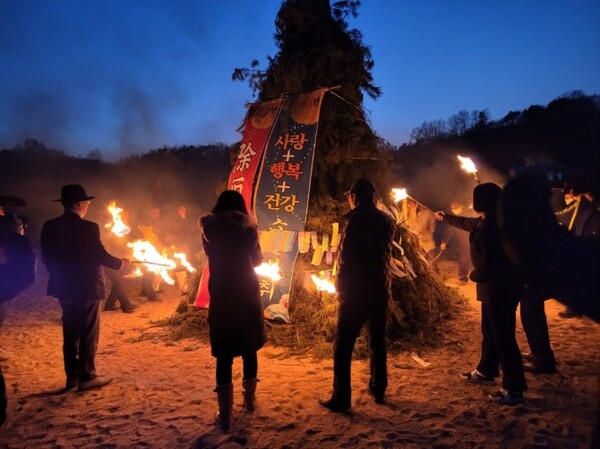 내성천 백사장에서 달집태우기 행사가 펼쳐지고 있다. 임기주 회장(왼쪽)이 주민들과 함께 쌓여있는 나무에 불을 붙이고 있다.  