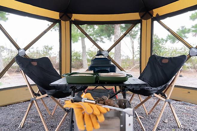 SK렌터카 제주 전기차 차박 쉘터 내 마련된 테이블과 의자, 화로, 랜턴 등 다양한 용품