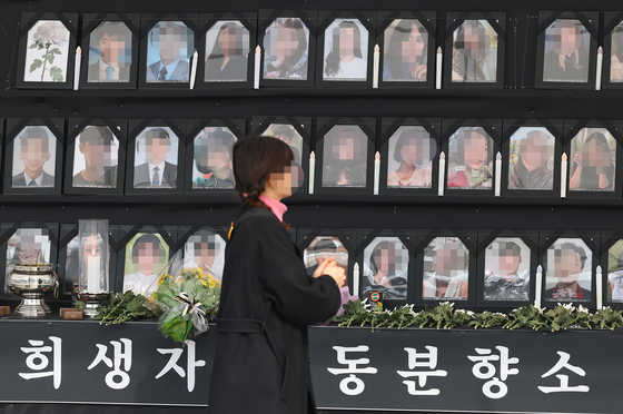 A visitor shows respect to the people who died from the Itaewon tragedy on Oct. 29 2022 during Halloween weekend at a makeshift memorial set up next to Seoul City Hall on Tuesday. [YONHAP]