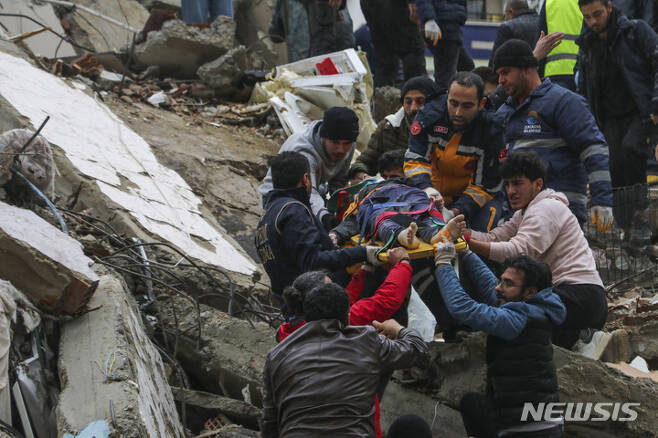 [아다나=AP/뉴시스] 6일(현지시간) 튀르키예 남부에서 발생한 규모 7.8의 강진으로 아다나에서 구조대와 주민들이 무너진 건물 잔해에 있던 생존자를 구조해 옮기고 있다. 이번 지진으로 지금까지 튀르키예에서 최소 76명, 시리아에서 최소 99명이 숨진 것으로 나타났다. 2023.02.06.