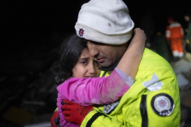 튀르키예 하타이에서 한 경찰관이 동료들과 함께 건물 잔해에서 구조한 딸을 안고 있다. 사진=AFP 연합뉴스