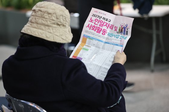 지난해 12월 15일 오전 한 시민이 서울 마포구청에서 열린 노인 일자리 박람회에서 안내문을 읽고 있다. 연합뉴스
