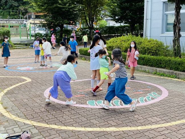전북 지역 아이들이 지난해 9월 3일 전북 전주시 완산구 전주남초 운동장에서 열린 팝업 놀이터 ‘삐뚤빼뚤 놀이터’ 각종 프로그램에 참여하고 있다. 아이들이 전통놀이인 안경놀이 재미에 푹 빠져있다. 초록우산어린이재단 제공