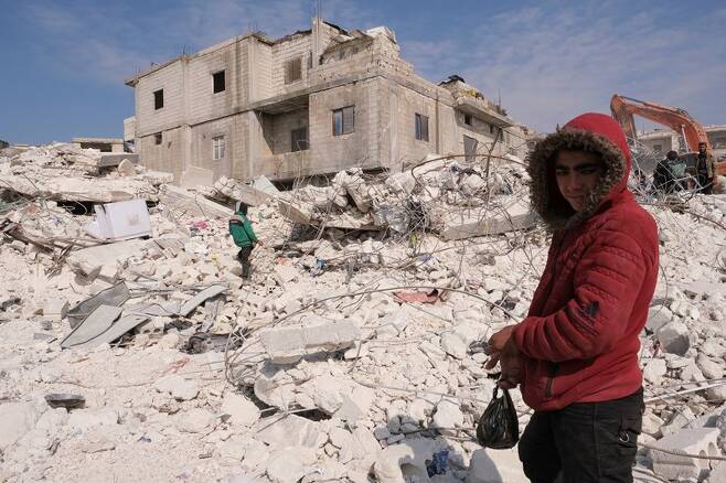 시리아 하렘 마을의 한 소년이 지진 여파로 무너진 건물 위에 서 있다. 로이터 연합뉴스