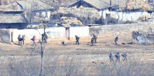 20일 북한의 황해북도 개풍군 유정동 마을에서 주민들이 지게를 지고 '퇴비전투'에 참여하고 있다.