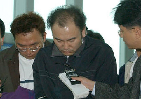 범행 1년 1개월만인 2003년 4월 11일 도피 중이던 중국에서 체포돼 국내로 압송되던 유남신과 김용기. (사진=연합뉴스)