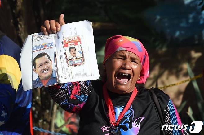 5일(현지시간) 베네수엘라 카라카스에서 열린 우고 차베스 전 대통령 10주기 기념행사에서 지지자가 차베스 전 대통령의 사진을 들어올리고 있다. ⓒ AFP=뉴스1 ⓒ News1 박재하 기자