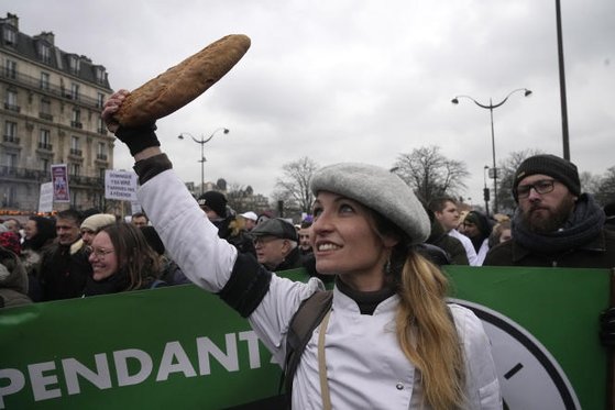 2023년 1월 23일 프랑스 파리에서 한 제빵사가 시위 도중 바게트를 움켜쥐고 있다. 수백 명의 제빵업계 종사자들이 이날 높은 재료비, 전기료 등으로 사업을 접을 위험이 있다며 시위를 벌였다. AP=연합뉴스