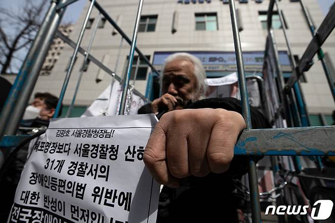 박경석 전국장애인차별철폐연대(전장연) 대표가 17일 오전 서울 종로구 서울지방경찰청 앞에서 몸에 쇠사슬을 두르고 철창 속에서 법원의 체포영장 발부에 따른 입장발표 기자회견을 하고 있다. 2023.3.17/뉴스1 ⓒ News1 이승배 기자