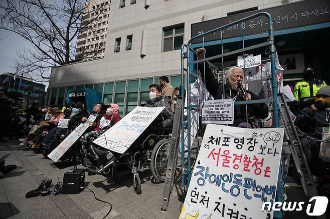 박경석 전국장애인차별철폐연대(전장연) 대표가 17일 오전 서울 종로구 서울지방경찰청 앞에서 몸에 쇠사슬을 두르고 철창 속에서 법원의 체포영장 발부에 따른 입장발표 기자회견을 하고 있다.  2023.3.17/뉴스1 ⓒ News1 이승배 기자