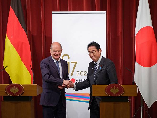 올라프 숄츠 독일 총리(왼쪽)와 기시다 후미오 일본 총리가 18일 도쿄 총리 관저에서 열린 기자회견에서 악수하고 있다.  【로이터연합뉴스】