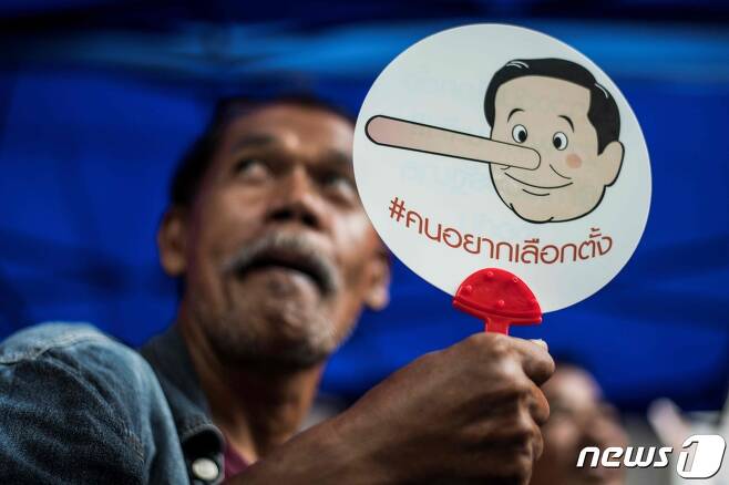 태국 방콕에서 군부 쿠데타 4주년을 맞아 반군부 시위에 나선 시민이 쿠데타로 집권한 쁘라윳 짠오차 총리를 피노키오로 풍자한 부채를 들고 있다. 2018.05.22. ⓒ AFP=뉴스1 ⓒ News1 박재하 기자