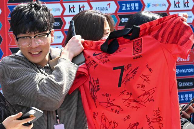20일 경기 파주시 국가대표 트레이닝 센터(NFC)에서 한국 축구대표팀 소집 전 기네스 '팬 하이파이브' 이벤트에 당첨된 팬이 손흥민 선수 유니폼에 받은 대표팀 선수들의 사인을 들어 보이고 있다. 파주=최주연 기자