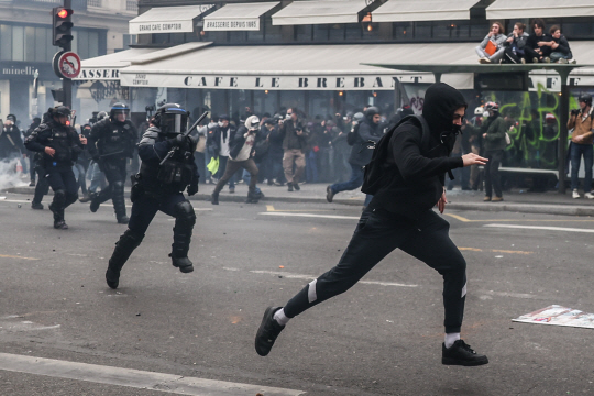 23일(현지시간) 프랑스 파리의 연금개혁 반대시위에서 경찰이 과격행동을 한 시위대를 뒤쫓고 있다. EPA·연합뉴스