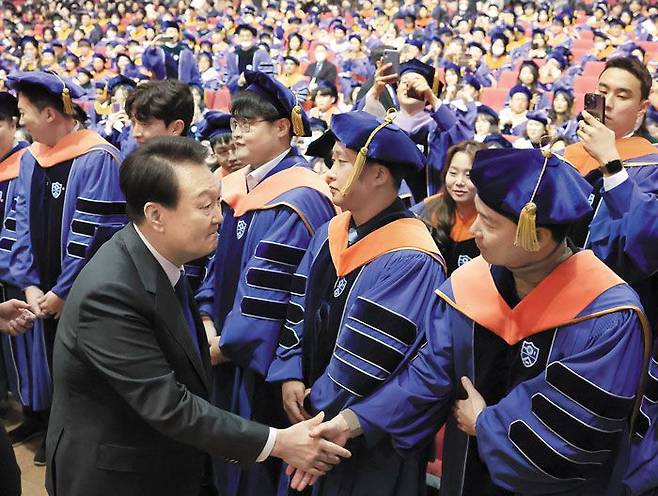 윤석열 대통령이 지난달 27일 연세대 학위수여식에서 축사를 마친 뒤 졸업생들과 악수하는 모습. 윤 대통령은 축사에서 "저와 정부는 여러분이 미래를 꿈꾸고 이야기할 수 있도록 우리 사회를 더 자유롭고 공정하게 바꾸고 개혁하기 위해 최선을 다할 것"이라고 했다. /대통령실